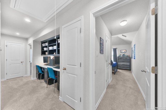 hallway featuring attic access, lofted ceiling, light colored carpet, and baseboards