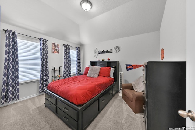 bedroom with lofted ceiling, light carpet, and baseboards