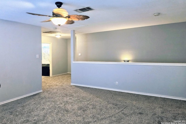 unfurnished room with carpet floors, a ceiling fan, visible vents, and baseboards