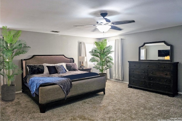 carpeted bedroom featuring ceiling fan, visible vents, and baseboards