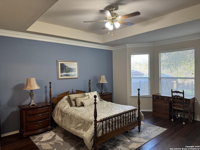 bedroom with crown molding, a raised ceiling, and wood finished floors