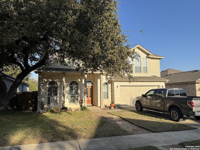 view of front facade featuring driveway, an attached garage, fence, and a front lawn