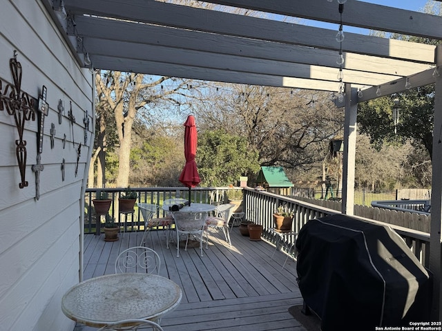 deck featuring grilling area, fence, outdoor dining area, and a pergola