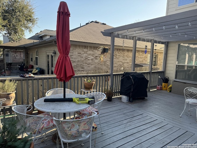 wooden deck featuring grilling area and a pergola