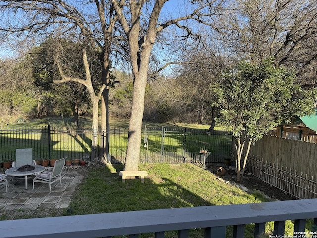 view of yard with a patio area, an outdoor fire pit, and fence