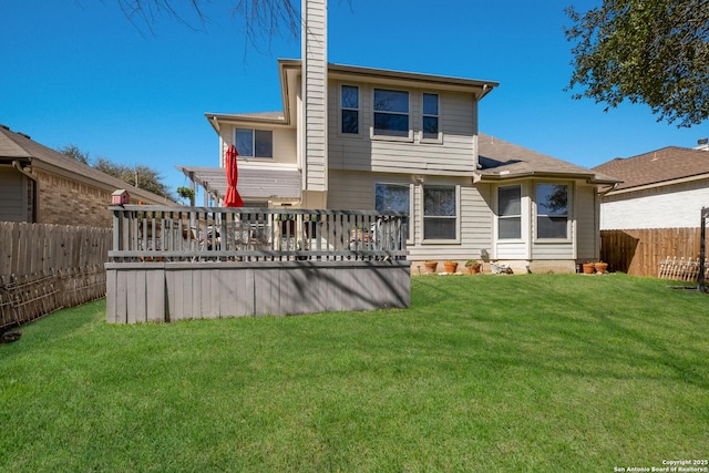 rear view of house featuring a fenced backyard, a yard, and a wooden deck