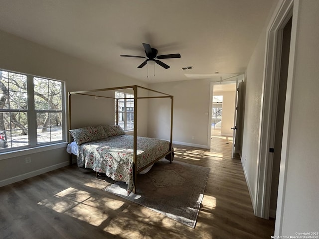 unfurnished bedroom with a ceiling fan, baseboards, visible vents, and wood finished floors