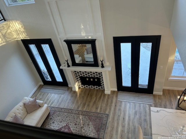 foyer entrance featuring french doors, baseboards, and wood finished floors