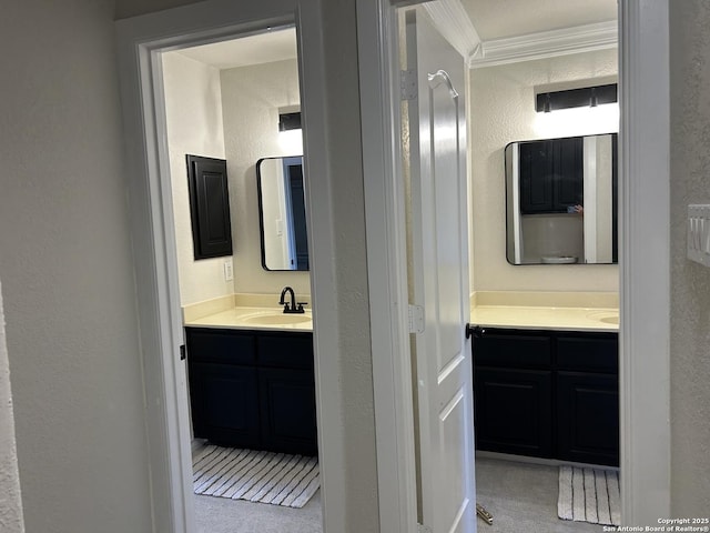 bathroom featuring ornamental molding, a textured wall, and vanity