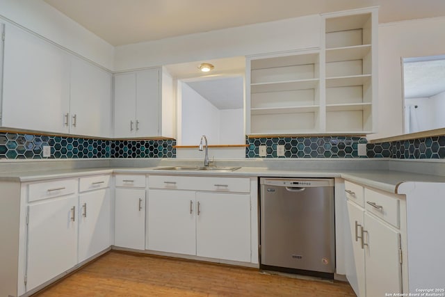 kitchen with open shelves, light countertops, stainless steel dishwasher, light wood-style floors, and a sink