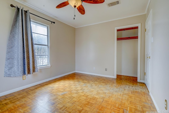 empty room with ornamental molding, visible vents, and baseboards