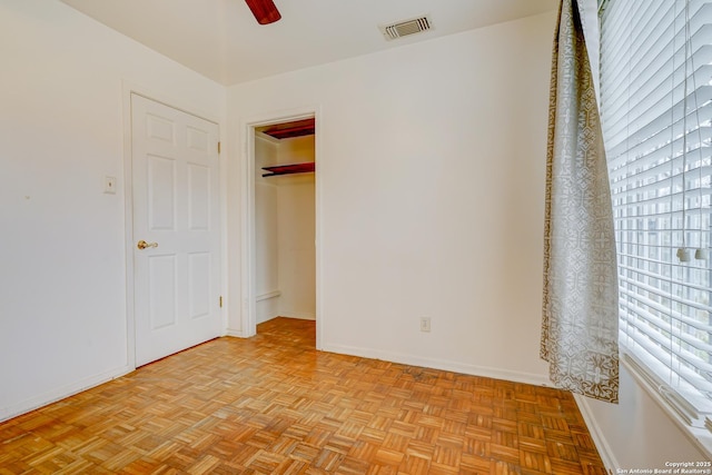 unfurnished bedroom featuring a ceiling fan, a closet, visible vents, and baseboards