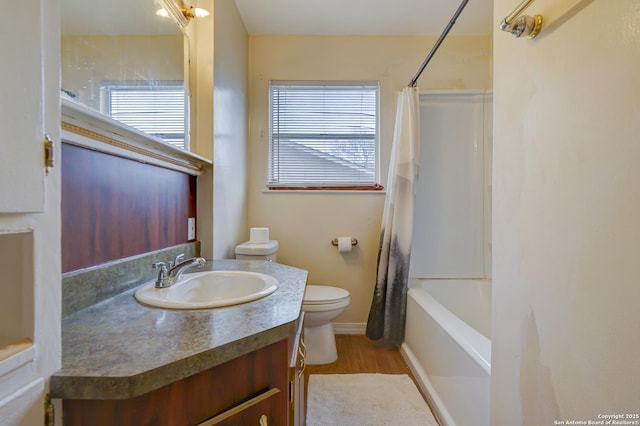 full bath featuring shower / bath combo, baseboards, toilet, wood finished floors, and vanity