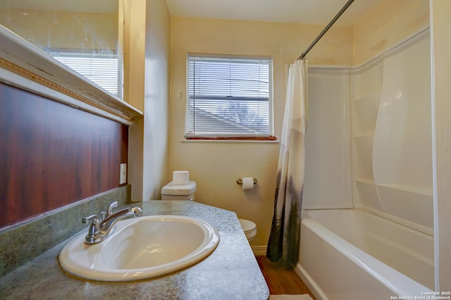 bathroom featuring wood finished floors, vanity, toilet, and shower / bath combo with shower curtain