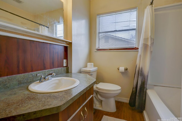 full bathroom with toilet, visible vents, wood finished floors, and vanity