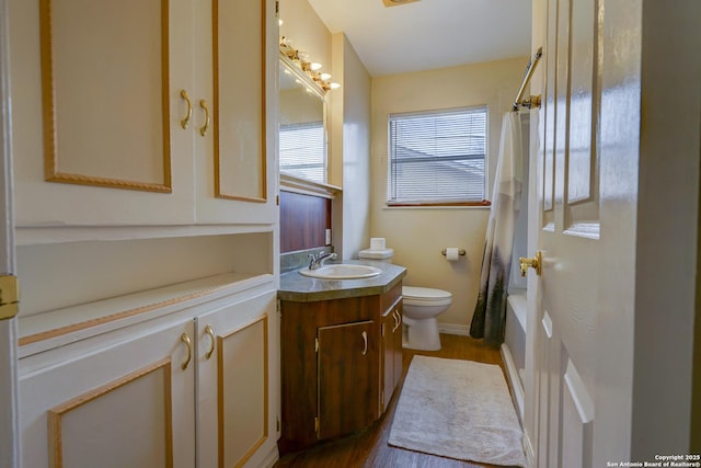 full bath featuring wood finished floors, vanity, toilet, and baseboards