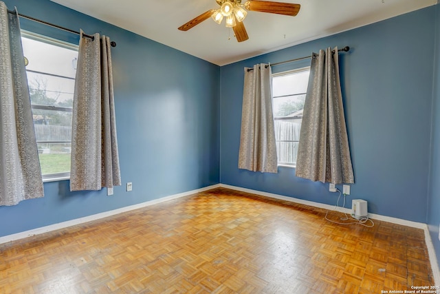 spare room with plenty of natural light, baseboards, and ceiling fan