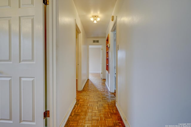 hall with baseboards and visible vents