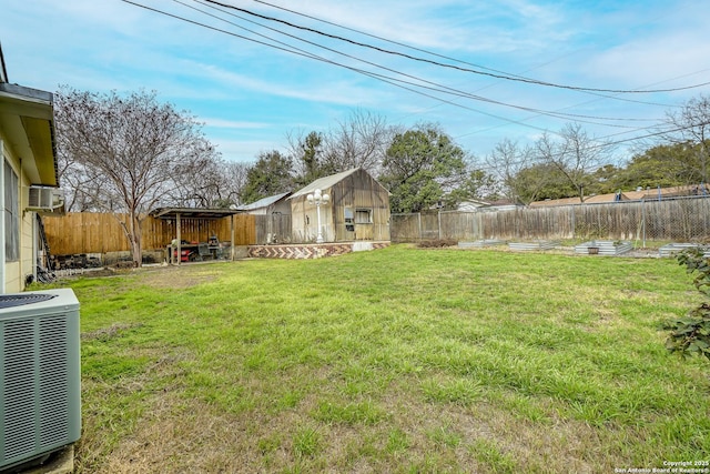 view of yard with an outbuilding, a fenced backyard, and central air condition unit