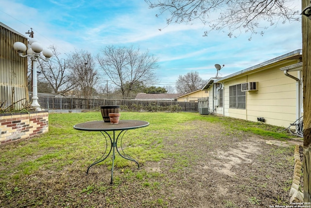 view of yard featuring a fenced backyard and a wall unit AC