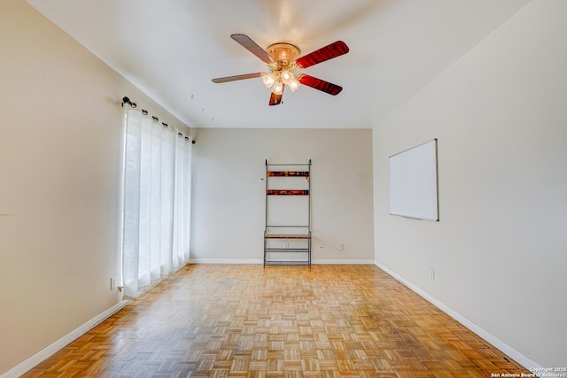 spare room featuring a ceiling fan and baseboards