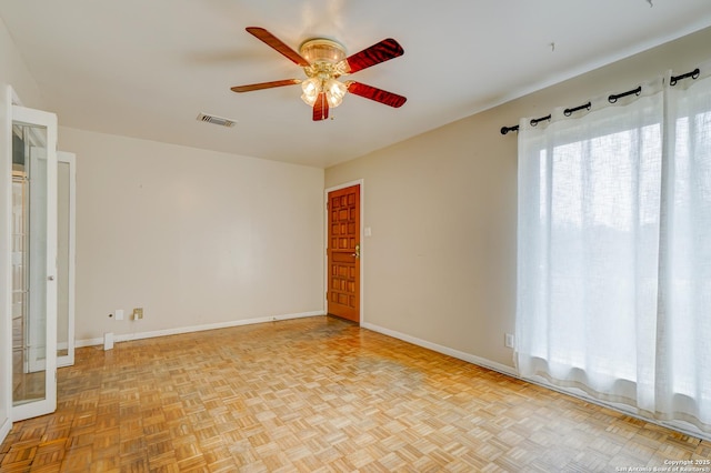 spare room featuring baseboards, visible vents, and a ceiling fan