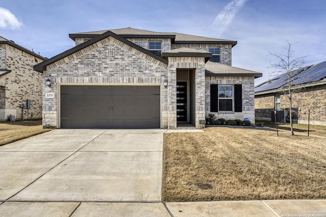 view of front of property featuring a garage, driveway, brick siding, stone siding, and a front yard