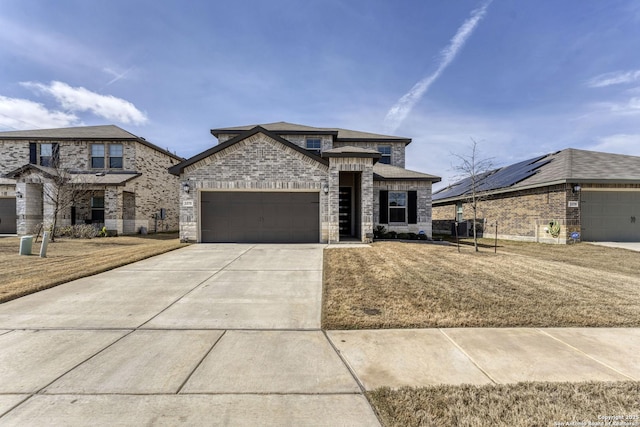 view of front of house with concrete driveway, brick siding, an attached garage, and a front yard