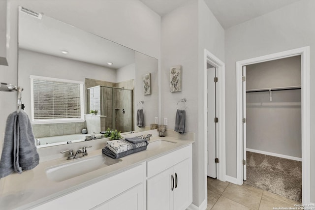 bathroom featuring a stall shower, a spacious closet, a sink, and tile patterned floors