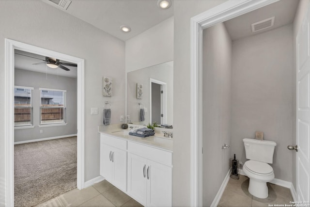 bathroom with toilet, a sink, visible vents, tile patterned floors, and double vanity