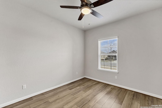 spare room featuring a ceiling fan, baseboards, and wood finished floors