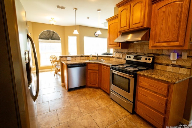 kitchen featuring tasteful backsplash, appliances with stainless steel finishes, a sink, a peninsula, and under cabinet range hood