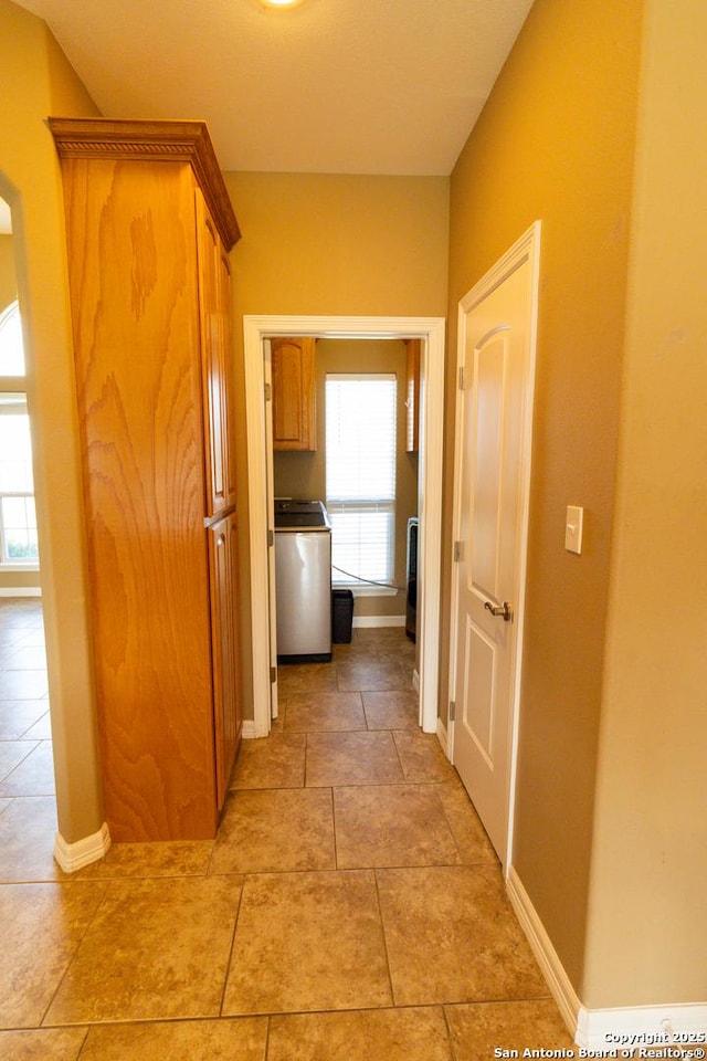 corridor with washer / dryer and baseboards