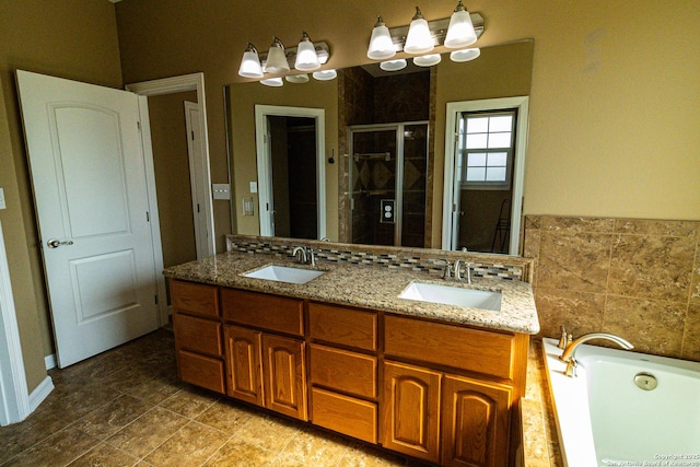 full bathroom with a stall shower, double vanity, a sink, and a bath