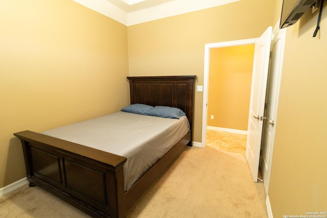 bedroom with baseboards and light colored carpet