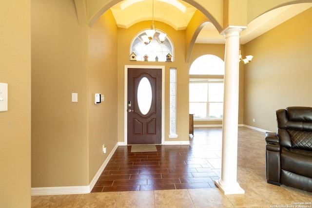 foyer featuring decorative columns and baseboards