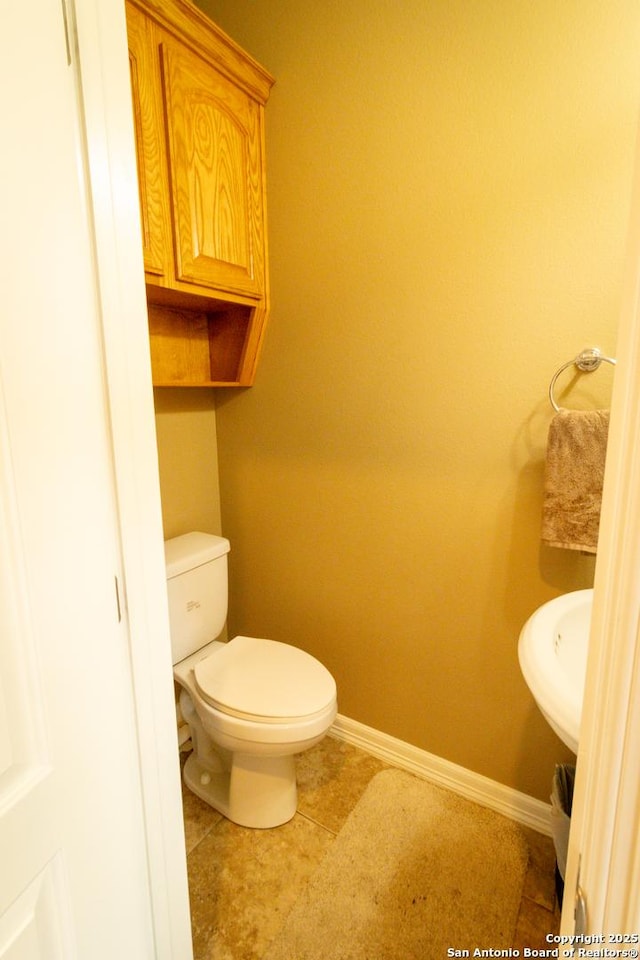 bathroom featuring a sink, tile patterned flooring, toilet, and baseboards