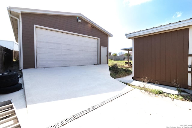 detached garage featuring fence