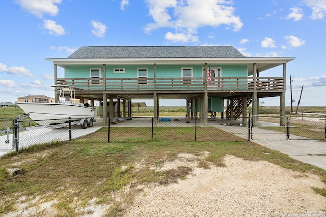 back of property with concrete driveway, covered porch, a gate, fence, and a carport