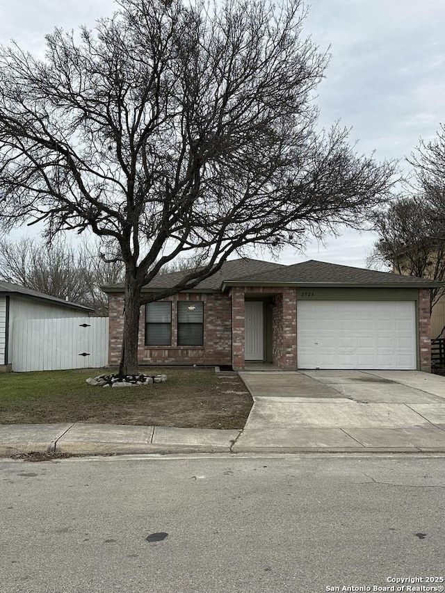 view of front of property with a garage, concrete driveway, brick siding, and a shingled roof