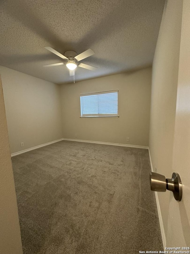 empty room featuring ceiling fan, a textured ceiling, carpet flooring, and baseboards