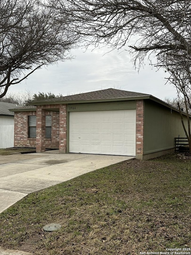 exterior space with concrete driveway, brick siding, and an attached garage