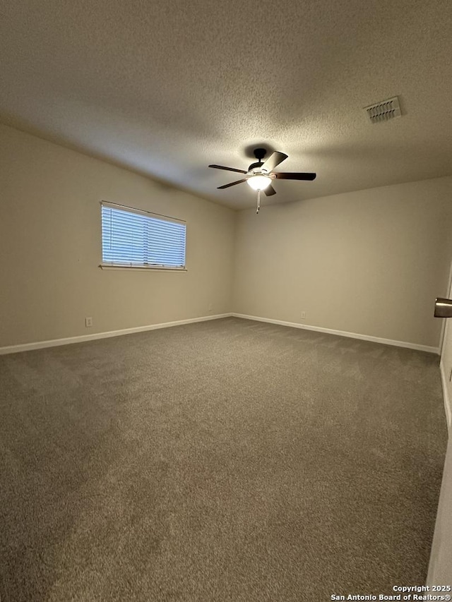 unfurnished room featuring baseboards, dark carpet, visible vents, and a ceiling fan