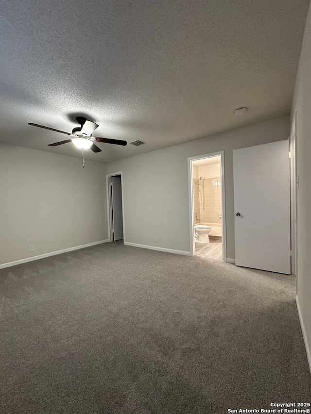 carpeted empty room featuring baseboards, a textured ceiling, visible vents, and a ceiling fan