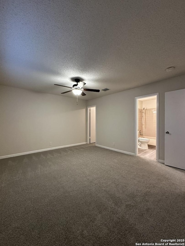 carpeted spare room featuring ceiling fan, a textured ceiling, visible vents, and baseboards