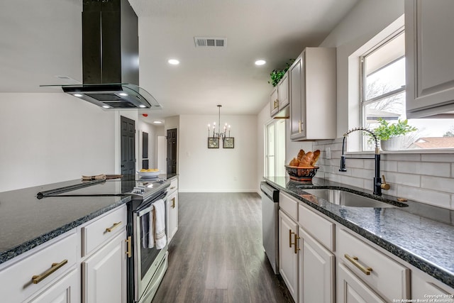 kitchen with visible vents, a sink, decorative backsplash, stainless steel appliances, and island range hood