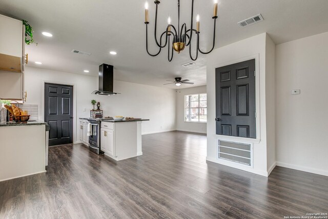 kitchen featuring dark countertops, visible vents, stainless steel range with electric stovetop, and ventilation hood