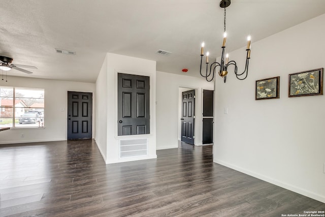 interior space with dark wood finished floors, ceiling fan with notable chandelier, and visible vents