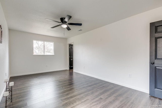 unfurnished room with ceiling fan, visible vents, baseboards, and dark wood finished floors