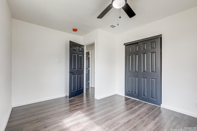 unfurnished bedroom featuring visible vents, baseboards, wood finished floors, a closet, and a ceiling fan